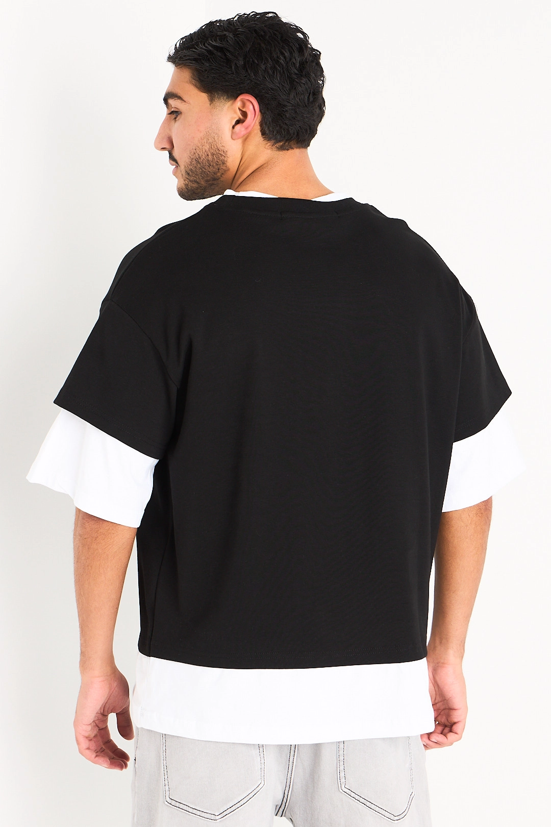 Tee-shirt noir à manches trois quarts blanches effet superposition et broderies